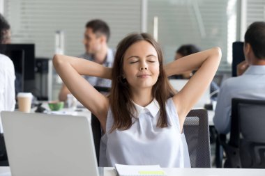 Sakin, genç bir çalışan. Sandalyede rahatla. İş yerinde rüya gör.