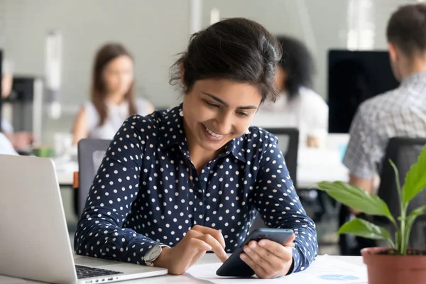 Impiegata sorridente utilizzando il cellulare che si prende una pausa dal lavoro — Foto Stock