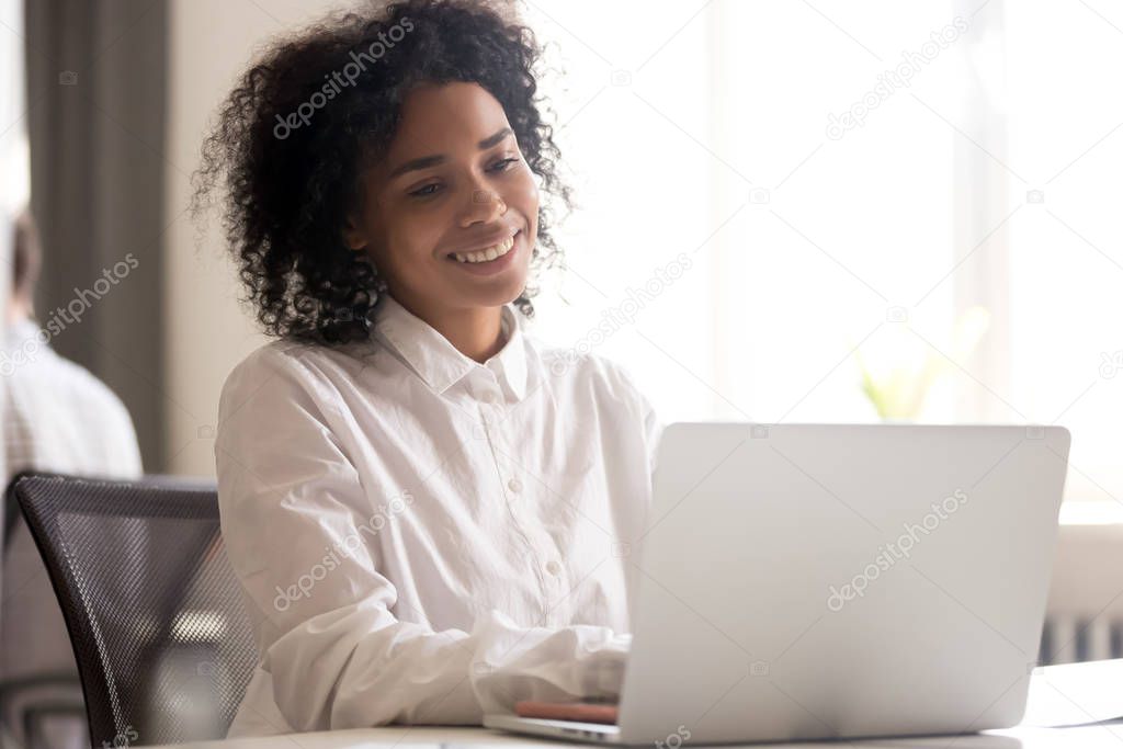 Happy black employee get pleasant message on laptop