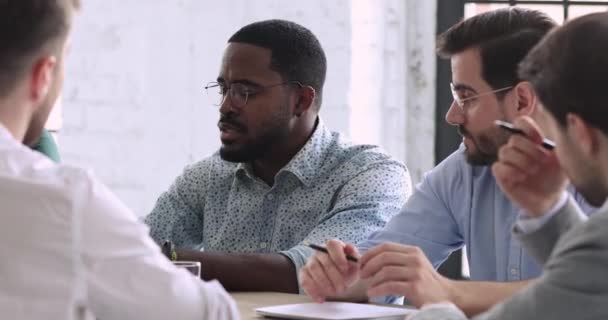 Afrikaanse zakenman in gesprek met multiraciale partners zitten op groepsvergadering — Stockvideo