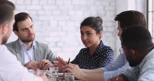 Jovem empresária indiana negociando com diversos empresários à mesa do escritório — Vídeo de Stock