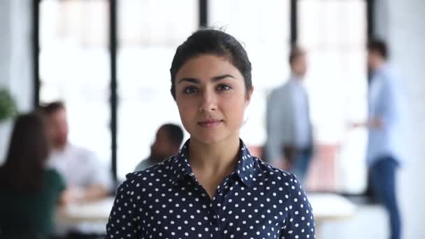 Sonriente joven mujer de negocios india confiada mirando a la cámara en la oficina — Vídeos de Stock