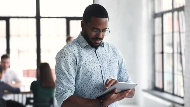 Empresário profissional africano usando tablet digital em pé no escritório — Vídeo de Stock