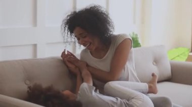Mutlu, Afrikalı, etnik kökenli bir kadın küçük tatlı kızıyla oynuyor..