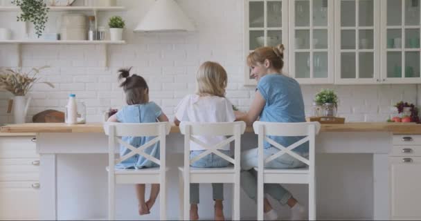 Niñera joven niñera comunicarse con dos niñas niños pequeños . — Vídeo de stock