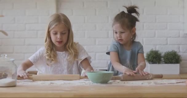 Twee kleine lachende kinderen zusters betrokken bij grappige koken activiteit. — Stockvideo