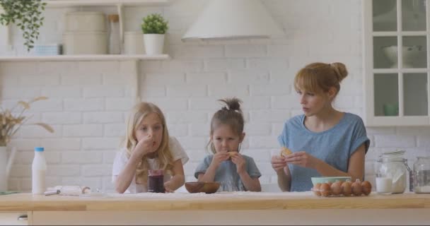 幸せな小さな子供たちとママはジャムと自家製クッキーを食べる. — ストック動画
