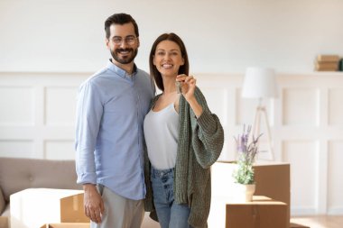 Portrait of happy couple show house keys moving together clipart