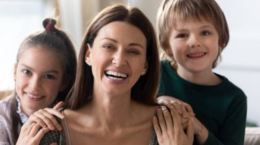 Mutlu anne ve küçük çocukların kucaklaşmasının portresi