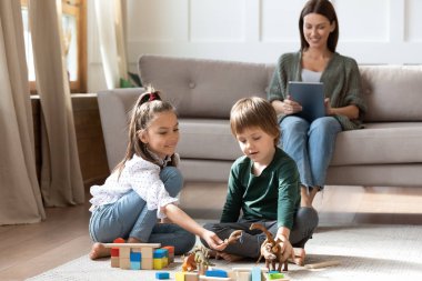 Gülümseyen çocuklar evde anneleriyle oynayarak eğleniyor.