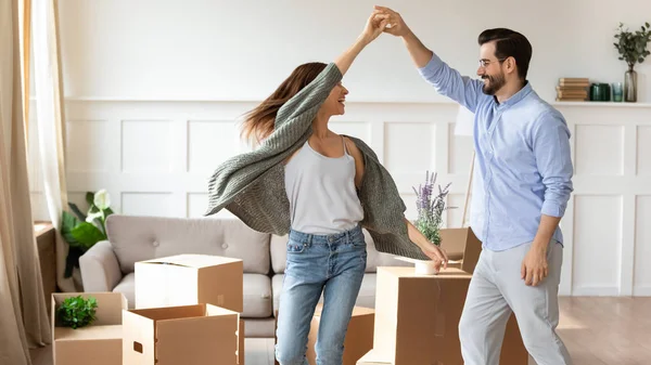 Overjoyed couple dance have fun on moving day — Stock Photo, Image
