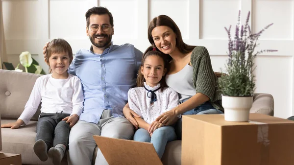 Retrato de familia feliz con niños trasladándose a un nuevo hogar — Foto de Stock