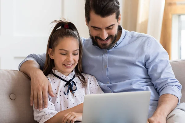 Happy dad cuddle with daughter use laptop together — Stock Photo, Image