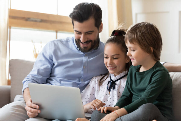 Happy father relax with kids watching cartoons on laptop