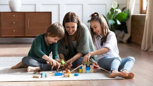 Loving mum sit on floor playing with little kids — Stock Photo, Image