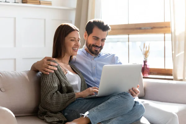 Glückliches Paar ruht auf Couch Video auf Laptop ansehen — Stockfoto