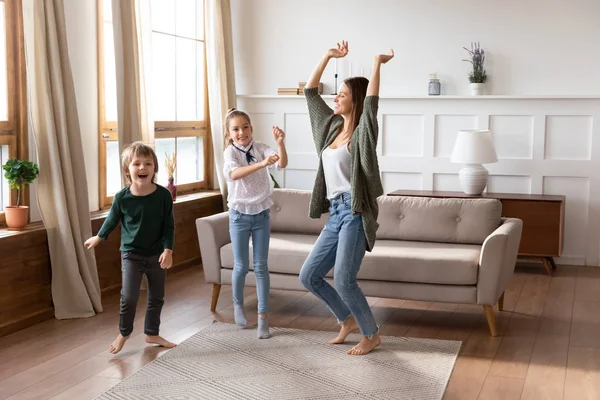 Przygnębiona mama dobrze się bawi tańcząc z małymi dziećmi w domu — Zdjęcie stockowe
