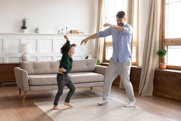 Lycklig ung pappa dansar hoppa med lille son — Stockfoto