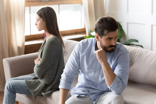 Angry young couple sit on couch avoid talking after fight — Stock Photo, Image