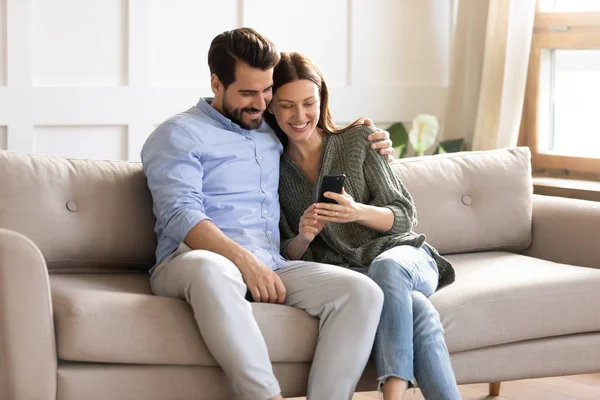 Lächelnder Mann und Frau entspannen gemeinsam mit Handy — Stockfoto