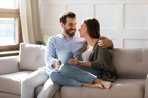 Millennium-Paar sitzt auf Couch und surft mit Tablet im Web — Stockfoto