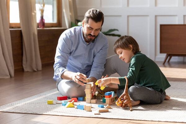Caring dad have fun playing with small son