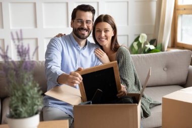 Gülümseyen çift yeni evine yerleşen kutuları açıyor.