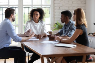 Çeşitli çalışanlar şirket brifinginde proje stratejisini tartışıyor