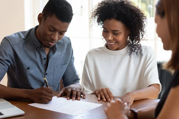 Happy African American couple signing contract, making deal — ストック写真