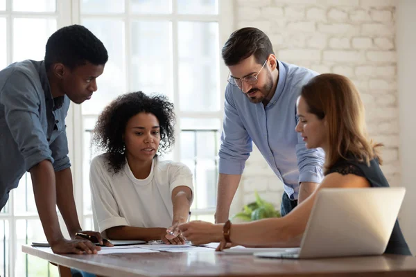 Diverse business team working together, discussing project documents — ストック写真