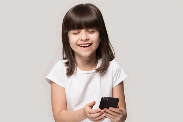 Happy adorable laughing preschool little girl holding smartphone. — Stock Photo, Image