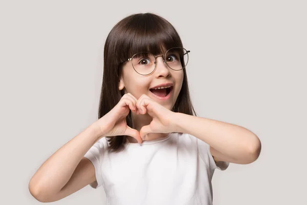 Nadšený školka malé rozkošné dívka v brýlích, ukazující lásku znamení. — Stock fotografie