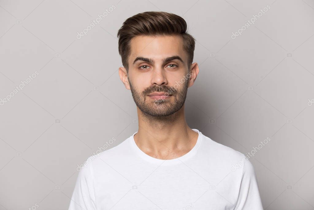 Millennial confident concentrated guy looking at camera portrait.
