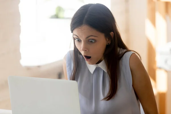 Businesswoman makes big eyes looking at computer screen feels shocked — Stock Photo, Image