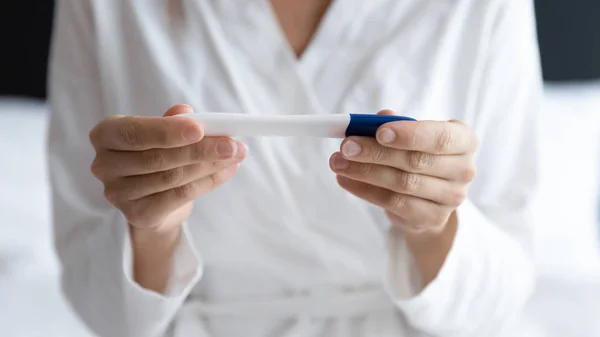 Close up young woman holding pregnancy test, checking result — Stock Photo, Image