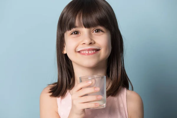 Sorrindo pré-escolar cutie segurando leite orgânico de vidro ou iogurte . — Fotografia de Stock