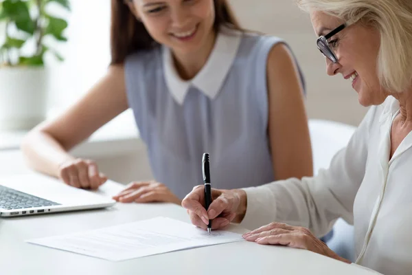 Mature woman satisfied client signing contract make deal affirming agreement — Stock Photo, Image