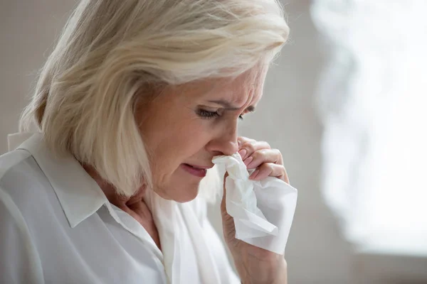 Aged woman holding napkin blows runny nose need antiviral medication — Stock Photo, Image