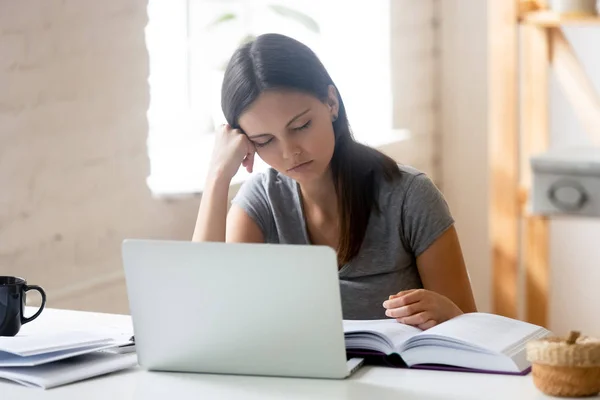 Übermüdete Studentin schlief am Tisch sitzend ein Stockbild