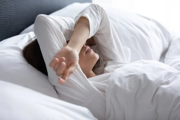 Sleepless young woman suffering from insomnia, covering eyes with hands — Stock Photo, Image