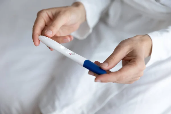 Close up young woman holding pregnancy test in hands — Stock Photo, Image