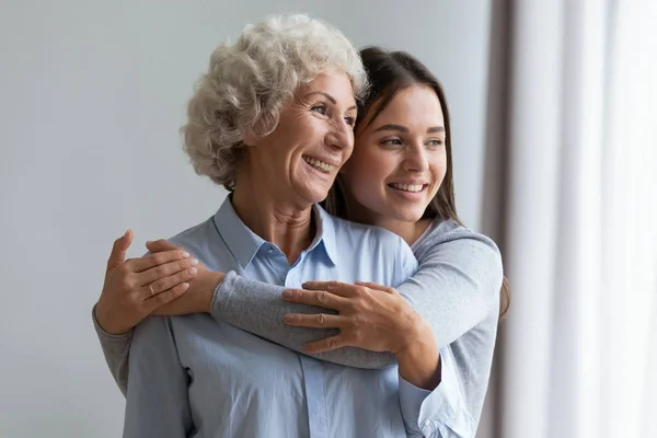 Felice nonna e nipote abbracciare, in piedi a casa — Foto Stock