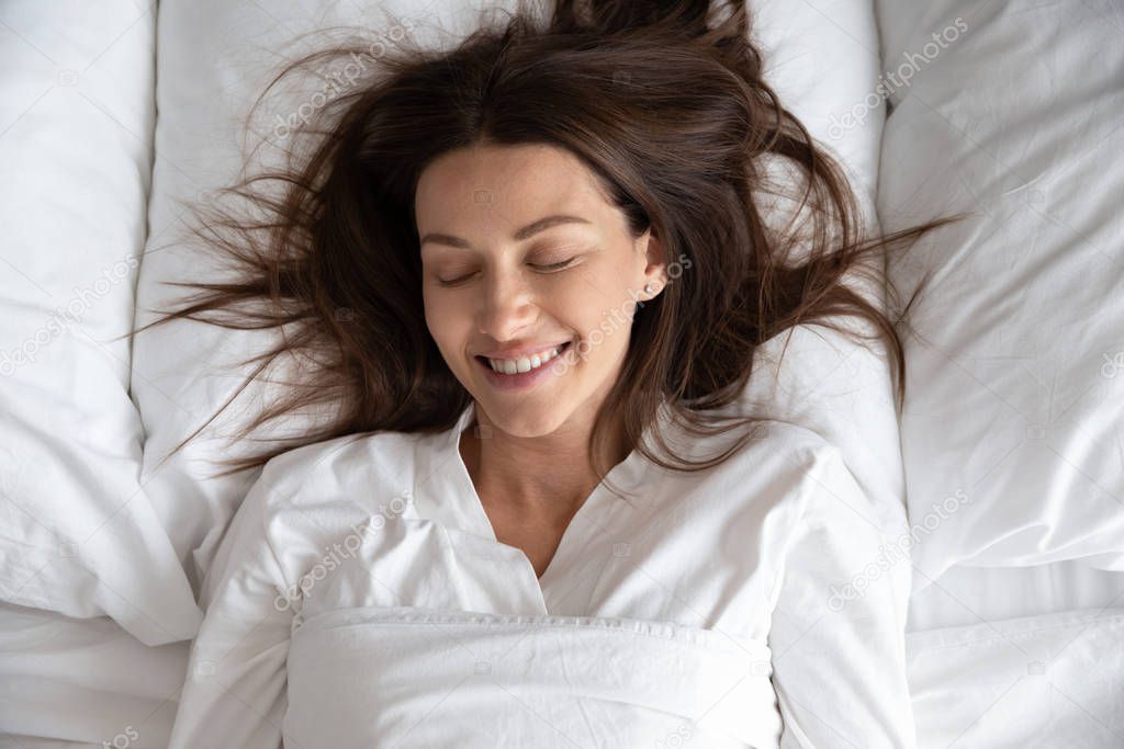 Head shot smiling beautiful woman wearing pajamas sleeping in bed