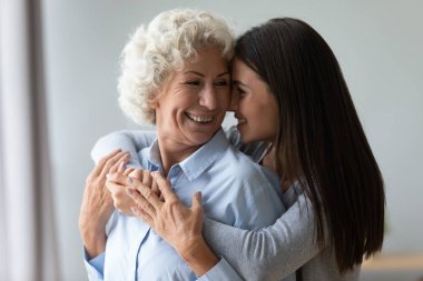 Gülümseyen büyükanne ve torun sarılıyor, hassas anın tadını çıkarıyorlar.