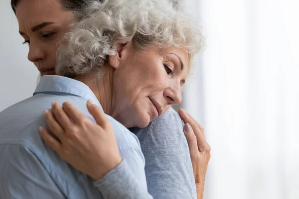 stock image Caring granddaughter comforting, hugging sad grandmother close up