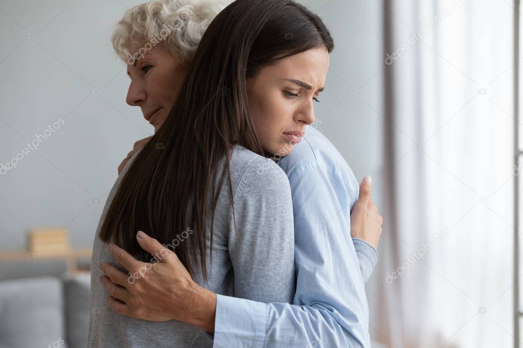 Caring grandmother comforting sad granddaughter, expressing love and support