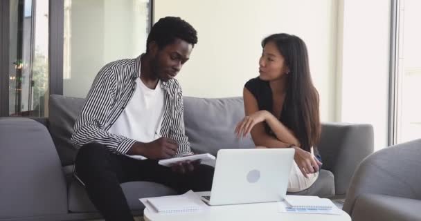 Felices socios de negocios multirraciales jóvenes discutiendo detalles del proyecto . — Vídeos de Stock