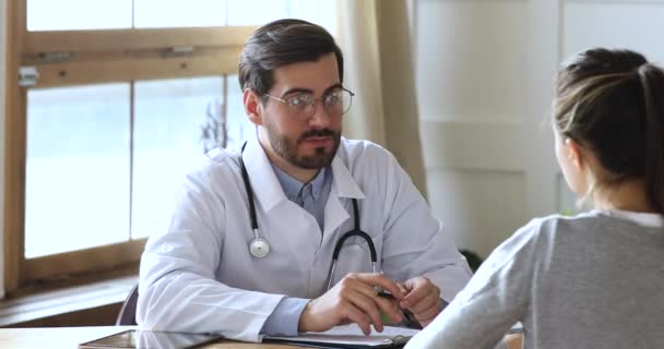 Lächelnder männlicher Arzt konsultiert Patientin beim Arztbesuch per Handschlag — Stockvideo
