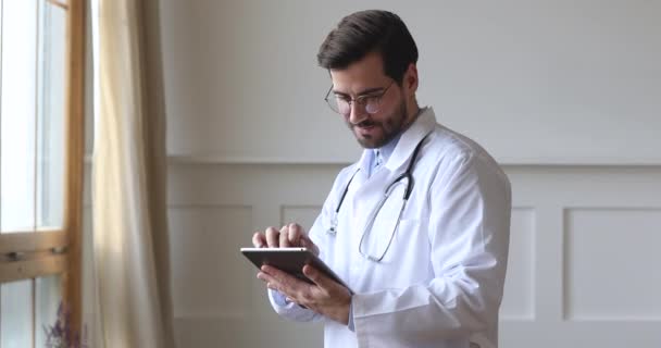 Muž profesionální lékař nosit bílou uniformu držení pomocí digitální tablety — Stock video