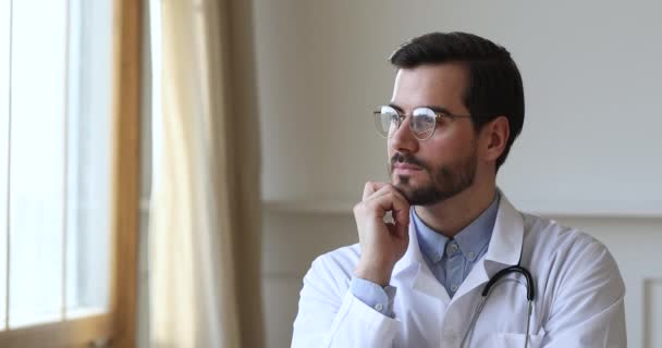 Framgångsrik omtänksam manlig professionell läkare titta genom fönstret drömmer tänkande — Stockvideo